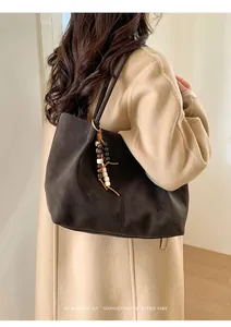 Detail of dark brown faux suede tote bag with minimalist beaded charm and retro vibe