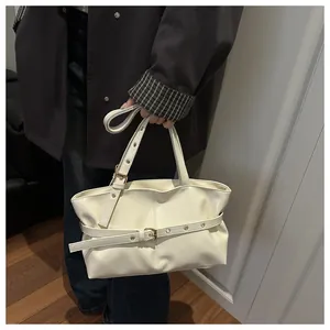 Detail of oil wax leather shoulder bag in cream with decorative metal eyelet strap