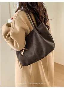 Detail of dark brown faux suede leopard tote with fringe tassel on female model