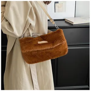 Brown faux fur crossbody bag with adjustable leather strap shown on a model side view
