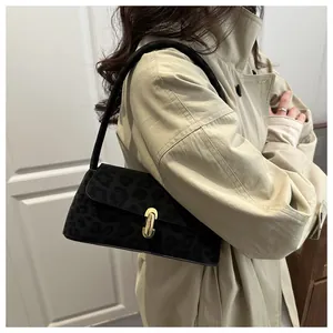 Detail of black leopard jacquard bag with gold metal buckle on a beige trench coat