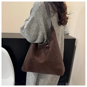 Dettaglio della grande borsa tote marrone scuro con cuciture bianche e consistenza morbida