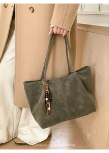 Detail of dark olive green faux suede tote bag with retro wooden bead accessory