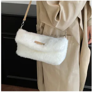 Detail of soft white faux fur shoulder bag with tan leather strap and metal hardware