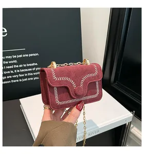 Detailansicht der weinroten Wildledertasche mit Stickerei und goldener Kette