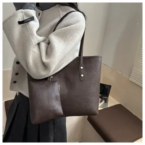 Detail of dark brown faux leather tote bag set with matching pouch and slim straps