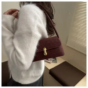Detail of burgundy leopard embossed shoulder bag with elegant gold metal buckle closure