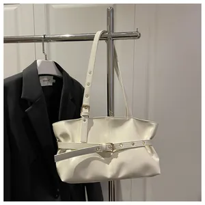 Close-up of white glossy oil wax leather shoulder bag with decorative buckle strap