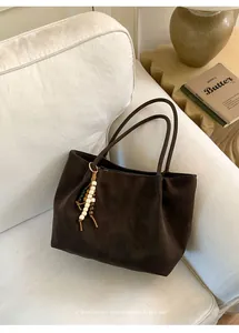 Detail of suede tote bag in coffee brown with beaded tassel and vintage texture