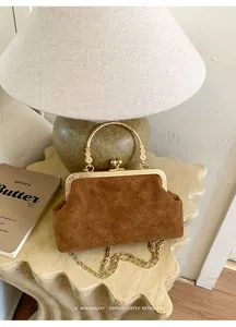 Details der braunen Wildledertasche mit Rich Rabbit Prägung und goldenem Metallgriff