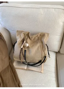 Dettaglio macro della borsa tote in pelle scamosciata kaki con coulisse e catena d'oro