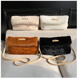 Detail of four colors of fuzzy plush crossbody bags with adjustable straps and logo tags