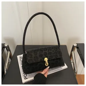 Detail of black leopard print suede shoulder bag with elegant golden metal buckle