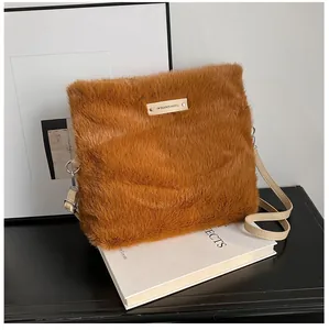 Detail of soft brown plush crossbody bag with textured faux fur and golden metal logo plate