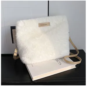 Detail of soft cream faux fur texture with adjustable brown strap and logo tag