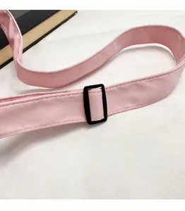 Close-up of adjustable pink nylon strap with black slider buckle for travel bag