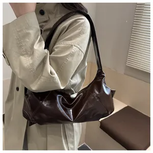 Detail of a shiny dark brown patent leather underarm bag with unique pleated texture