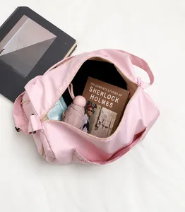 Detail view of pink large travel bag showing spacious interior with books and umbrella