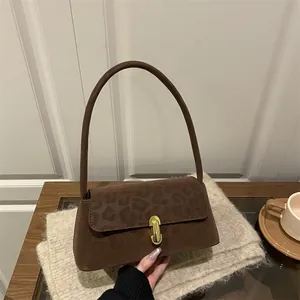 Brown faux suede shoulder bag with leopard print flap and golden metal clasp lock