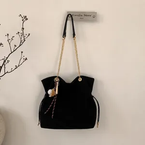 Borsa tote minimalista in pelle scamosciata nera con catena d'oro e ciondolo