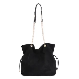 Borsa tote in camoscio nero con tracolla a catena dorata e dettagli di coulisse laterale