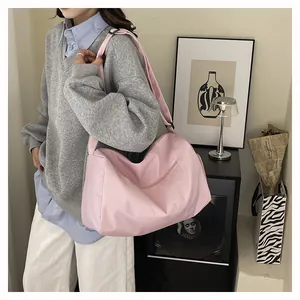 Stylish large pink travel bag shown with a model in a modern indoor setting