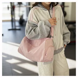 Detail of light pink waterproof travel bag showing side zipper pocket and adjustable strap