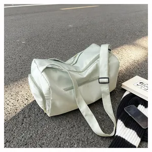 Detail of light green duffel bag showing water-resistant fabric and adjustable strap