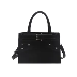 Classic black tote bag for women with decorative buckles and silver rivets on white background