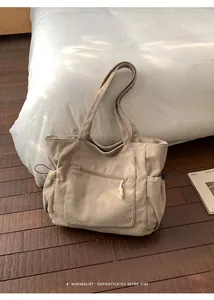 Close-up of beige corduroy tote bag showing the zipper front pocket and soft texture