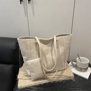 Chic beige oversized tote bag set with matching small pouch in elegant minimalist design