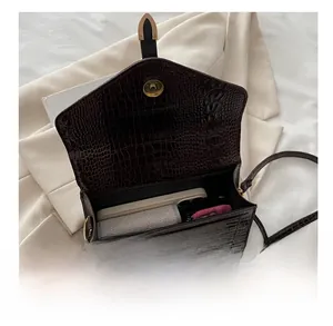 Macro view showing the internal capacity of the brown crocodile pattern crossbody bag