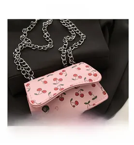 Nahaufnahme der rosa Mini-Klappentasche mit Kirschmuster, Silberkette und PU-Leder-Struktur