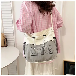 Close-up of beige canvas tote bag with WIRA letter print and drawstring top detail