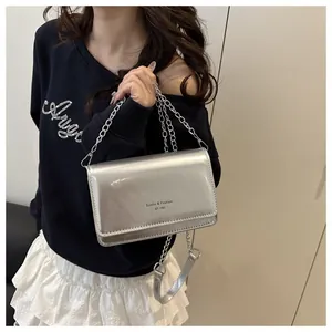 Detail van zilveren metallic crossbody tas met kettingriem en Sunita & Fashion opdruk