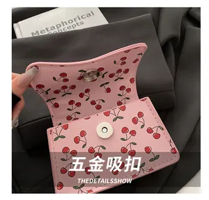 Detailaufnahme der rosa Kirsch-Tasche mit magnetischer Metallschnalle und feinen Nähten