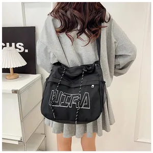 Detail of black ULTRA crossbody bag featuring drawstring design and mesh side pocket
