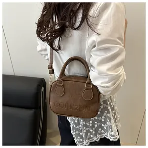 Detailed macro shot of vintage brown leather texture and embossed letters on handbag