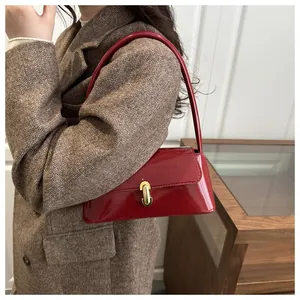 Deep red patent leather baguette bag styled on a brown herringbone wool coat