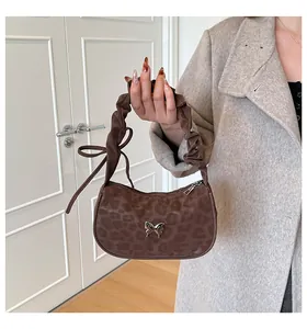 Detail of leopard print shoulder bag with metallic butterfly buckle and scrunchie handle
