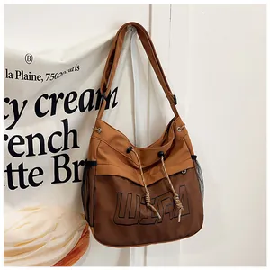 Detail of tan nylon tote bag showing mesh pockets and drawstring closure detail
