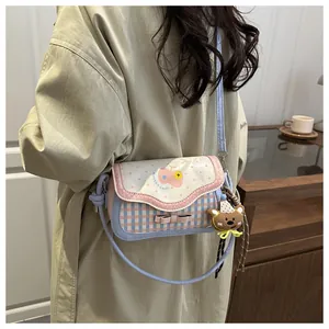 Detail of cute pink apple shoulder bag with wave edge lid and brown bear pendant
