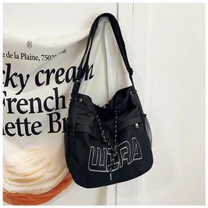 Detail of black nylon tote bag featuring mesh outer pocket and white ULTRA embroidery