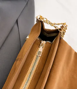 Macro-opname van de gouden rits en hardware op de bruine mat lederen crossbody tas