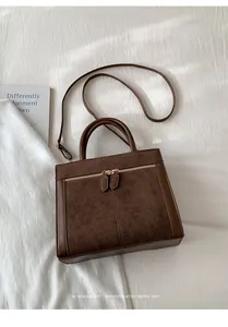 Detalle del bolso tote de ante y cuero marrón con un diseño retro minimalista