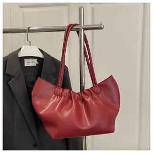 Detail of red bridal tote bag with pleated design and Fashion Bags logo on display stand