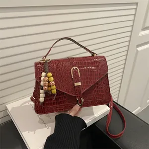 Minimalist burgundy crocodile pattern handbag with gold clasp and bead charm