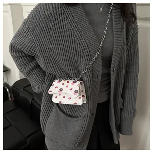 Nahaufnahme der weißen Mini-Umhängetasche mit Lippenprint und silberner Kette