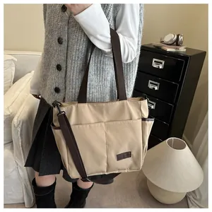Vue détaillée du sac cabas en toile beige avec plusieurs poches et anses marron