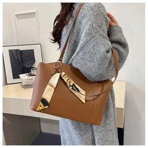 Vue détaillée du grand sac cabas en cuir marron avec foulard en soie géométrique